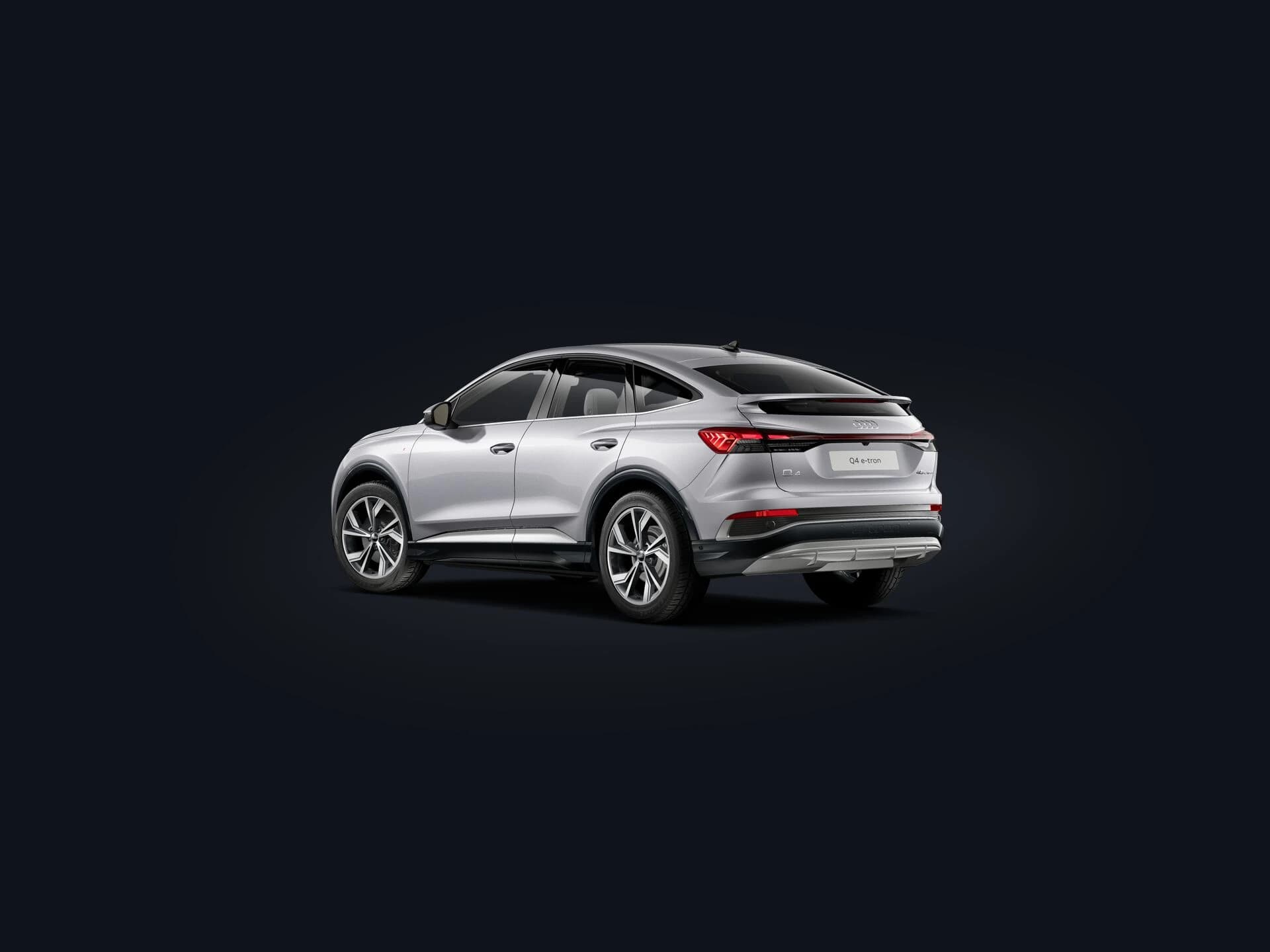 2026 Audi Q4 Sportback e-tron rear quarter showing the sloping coupe roofline and full-width LED light bar