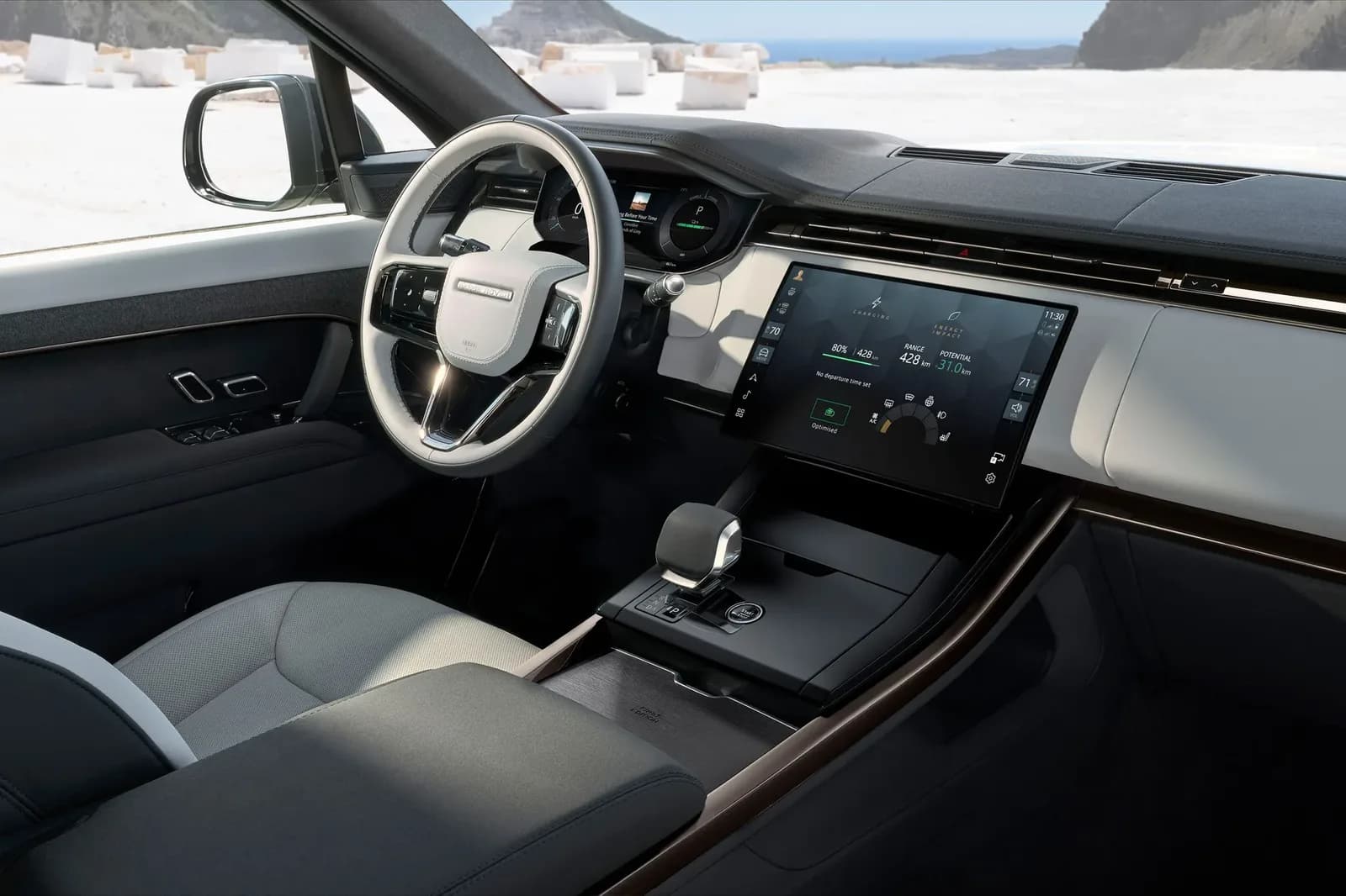 Left-hand-drive Range Rover Sport Electric cabin with light grey leather seats, a touchscreen showing charge level and range, and a gear selector on the centre console