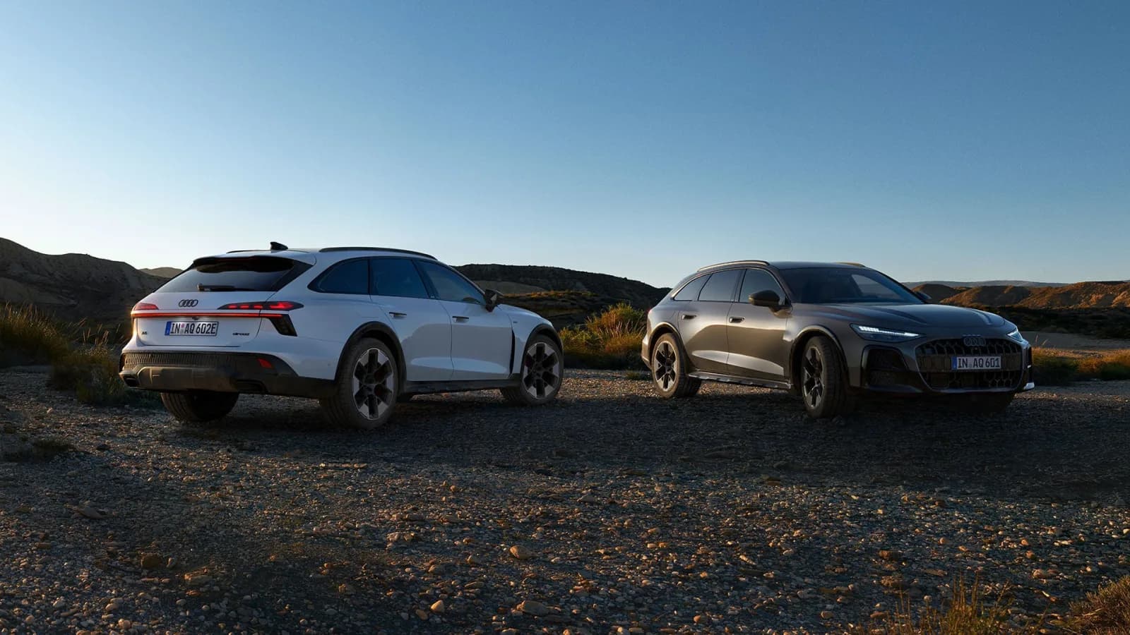 2027 Audi A6 allroad e-hybrid in white and A6 allroad TDI in grey parked on gravel