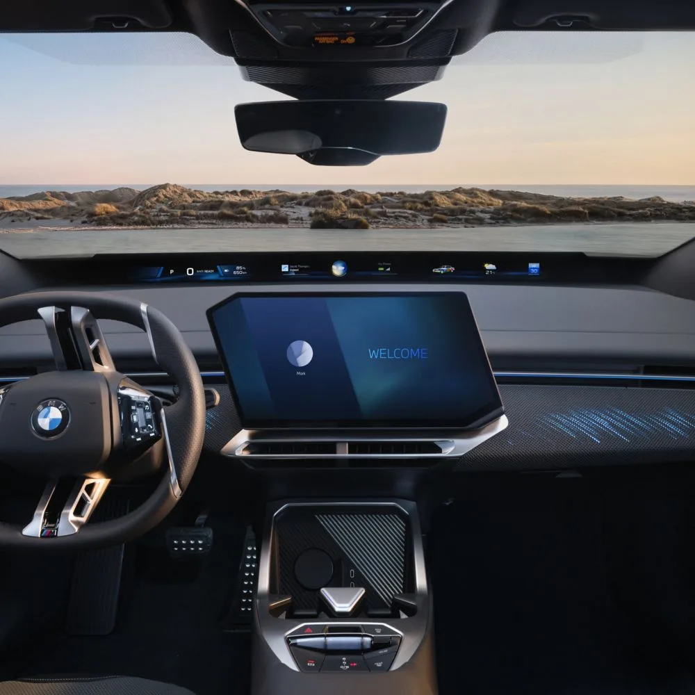 BMW iX4 interior with a central touchscreen and lit dashboard strip, overseas model