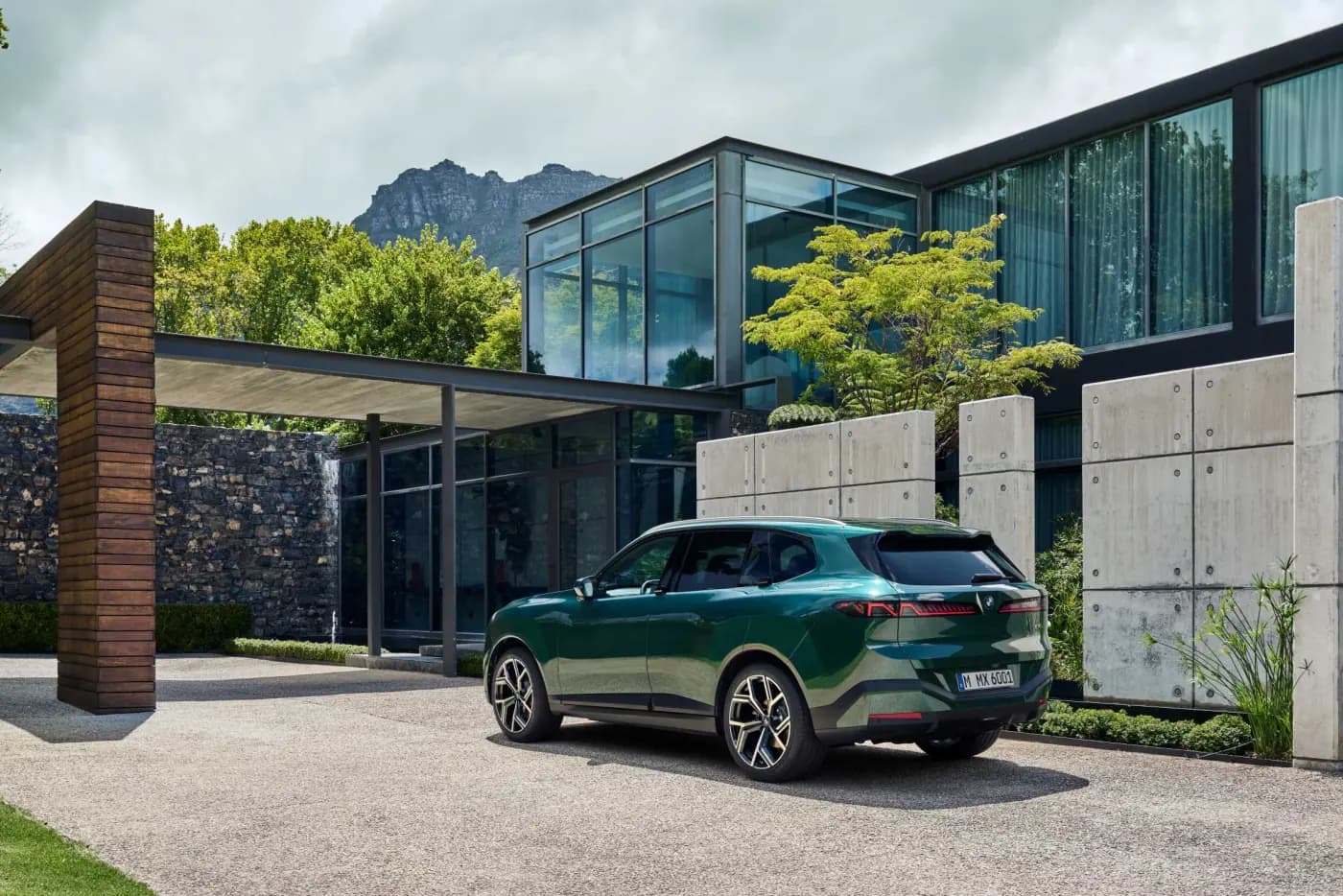All-new BMW X5 in dark green, rear three-quarter view showing the one-piece tailgate and full-width tail light treatment
