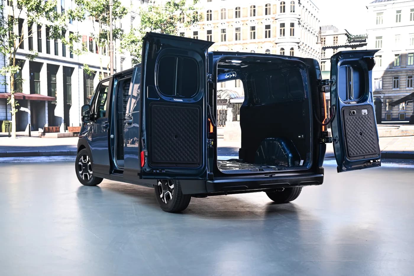 Kia PV7 Cargo with both rear barn doors and the side sliding door open, showing the empty load bay and flat floor