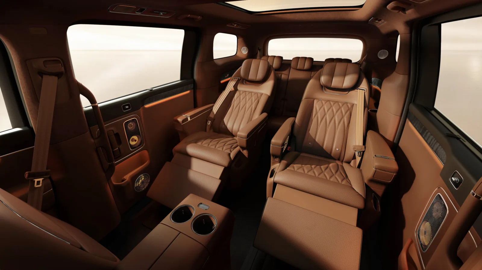 Luxeed LLounge cabin showing two tan leather second-row captain's chairs with extended leg rests and a third-row bench behind
