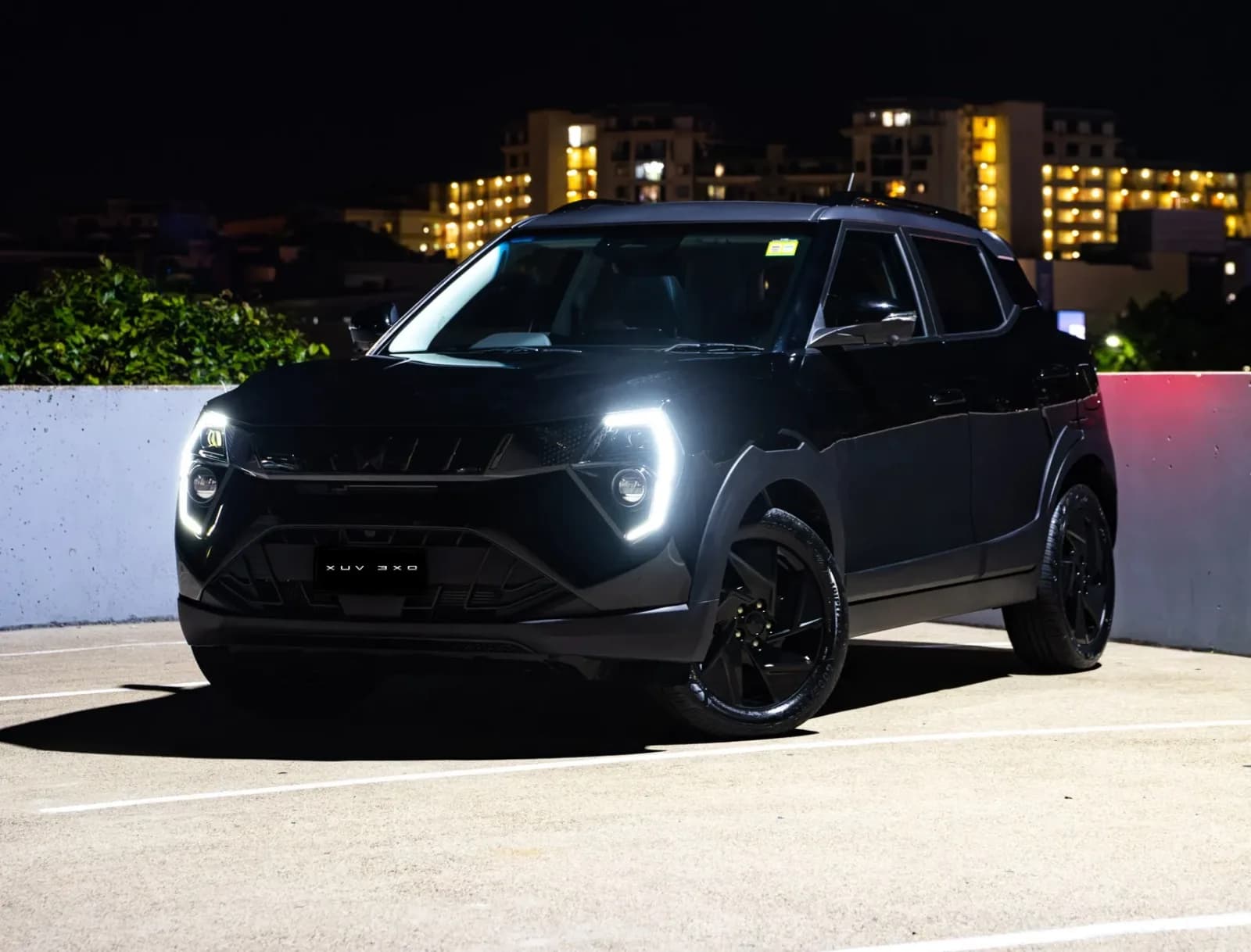 Mahindra XUV 3XO Black Anniversary Edition at night with LED daytime running lights lit, showing the gloss-black grille and 17-inch black alloys
