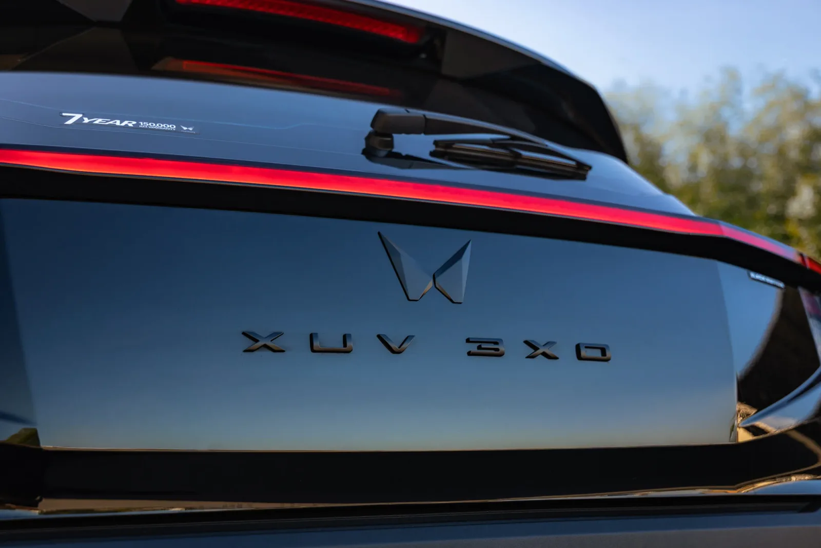 Tailgate of the Mahindra XUV 3XO Black Anniversary Edition showing blacked-out badging and the seven-year 150,000km warranty decal