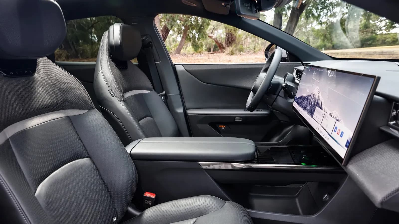 Mazda CX-6e driver's seat showing leather seats, centre console, and widescreen display