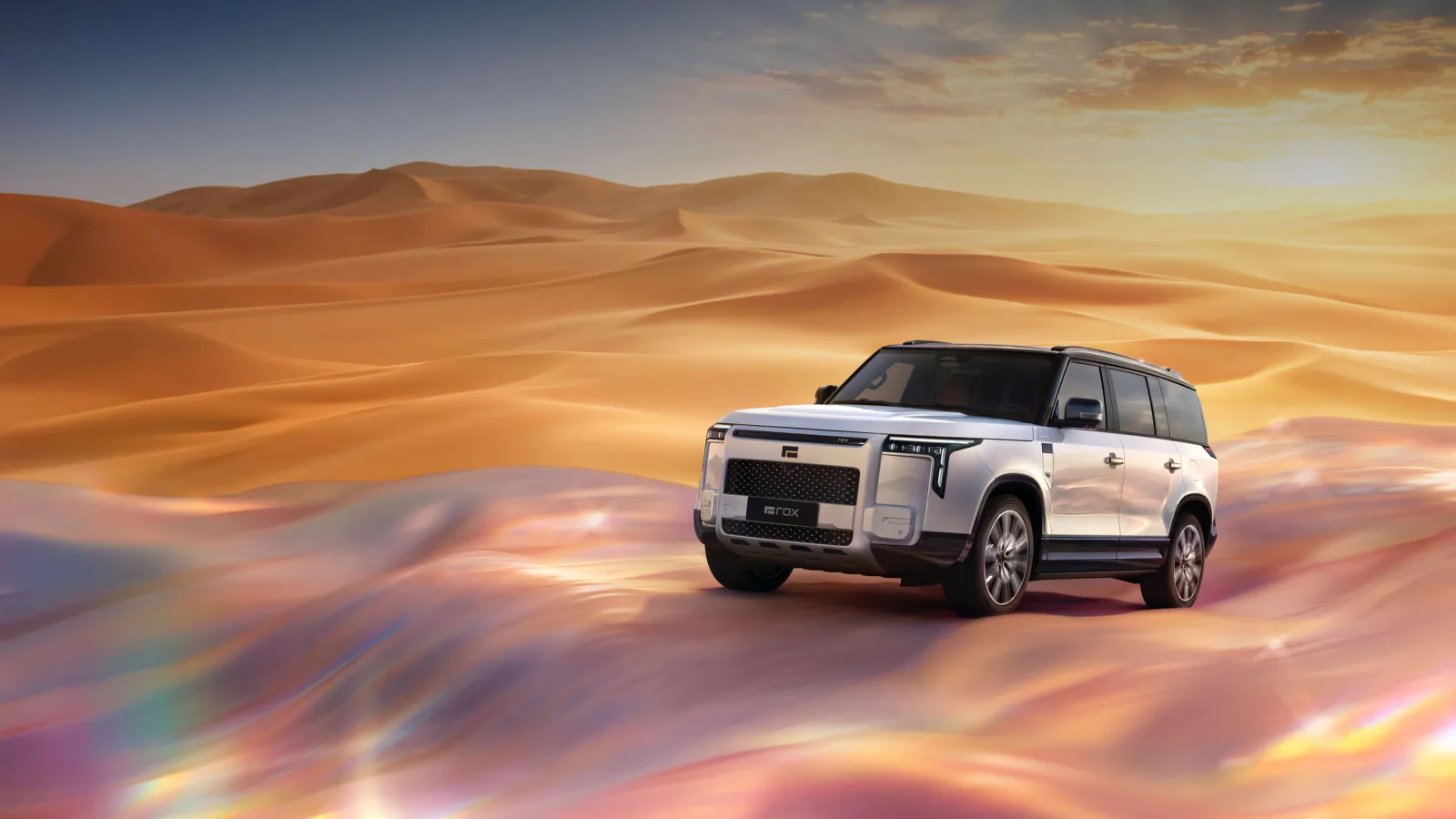 White Rox Adamas SUV with a boxy body and a rox plate on the grille, driving across orange desert dunes at sunset