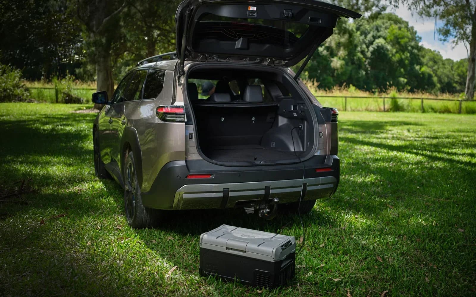 Toyota bZ4X Touring rear with tailgate up showing 550L boot and a portable fridge