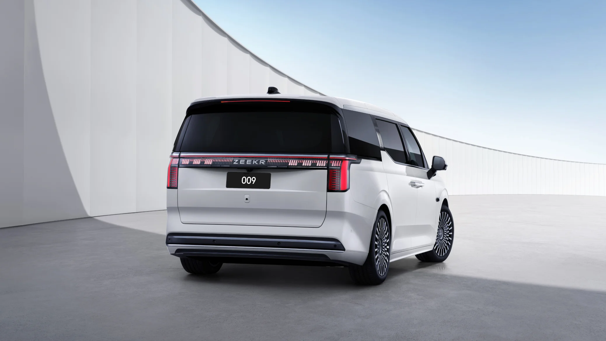 Zeekr 009 rear three-quarter view showing full-width LED tail light bar