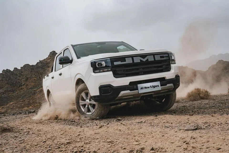 JMC Vigus dual-cab ute in white kicking dust on a rocky outback track