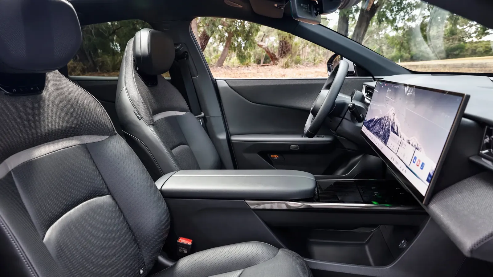 Mazda CX-6e driver's seat showing leather seats, centre console, and widescreen display