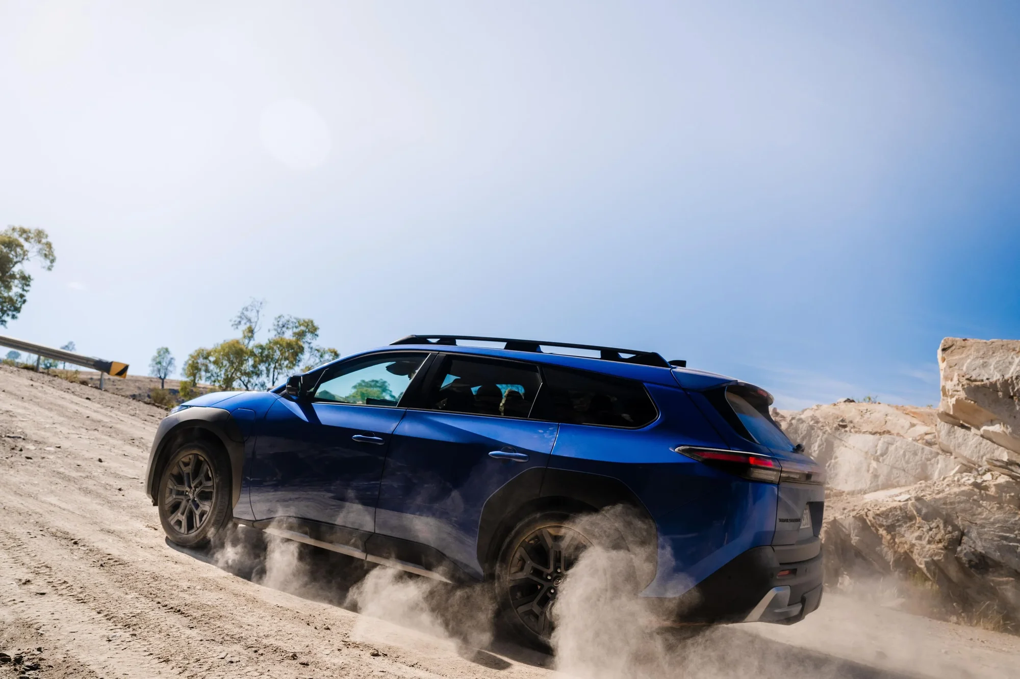 Subaru Trailseeker rear three-quarter kicking up dust on a sandy incline