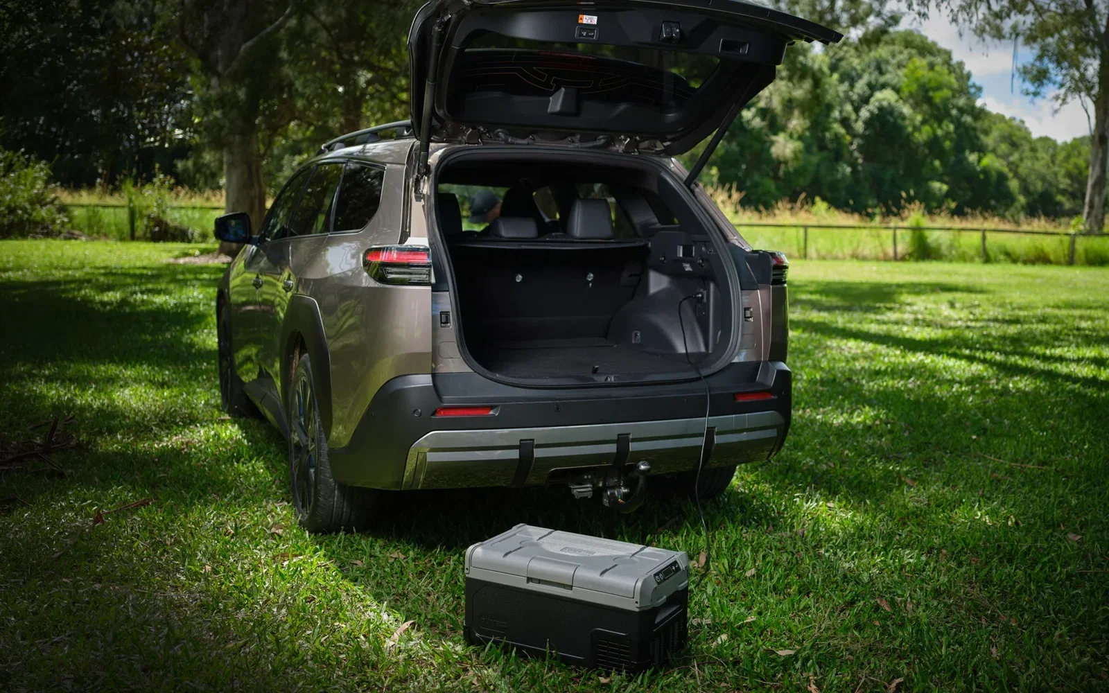 Toyota bZ4X Touring rear with tailgate up showing 550L boot and a portable fridge